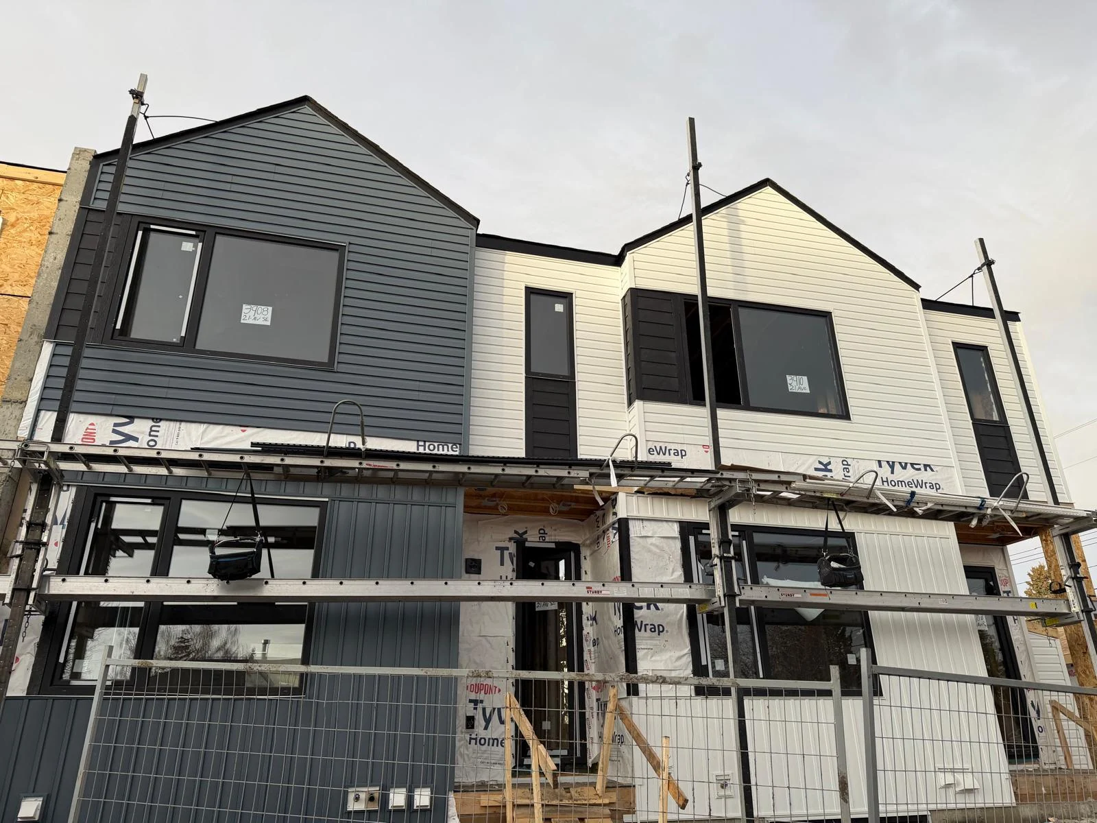 Paired charcoal and light exteriors with scaffolding